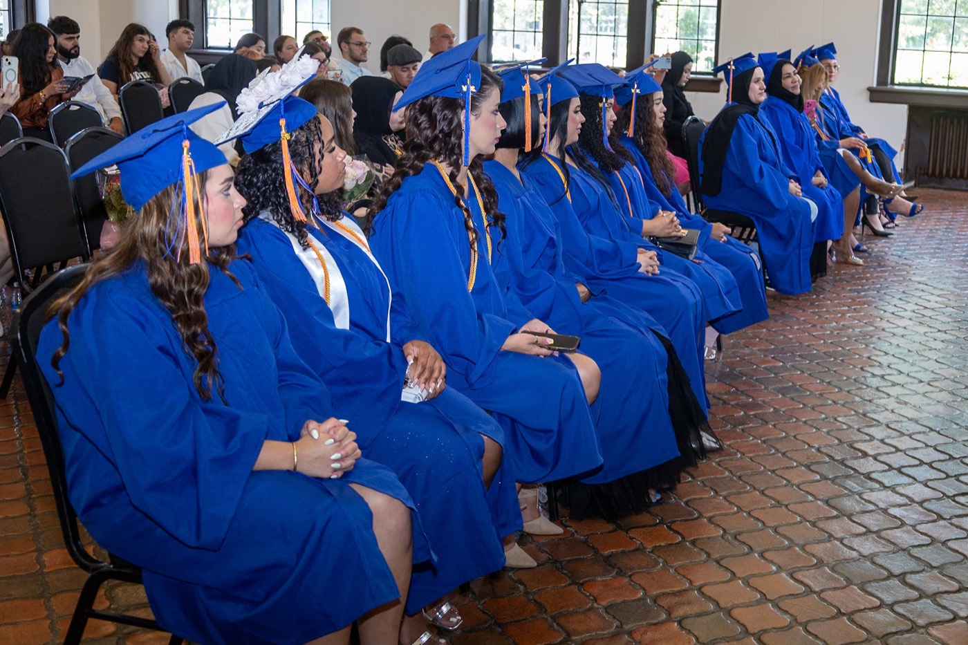 PCT graduates seated in blue caps and gowns during their graduation ceremony