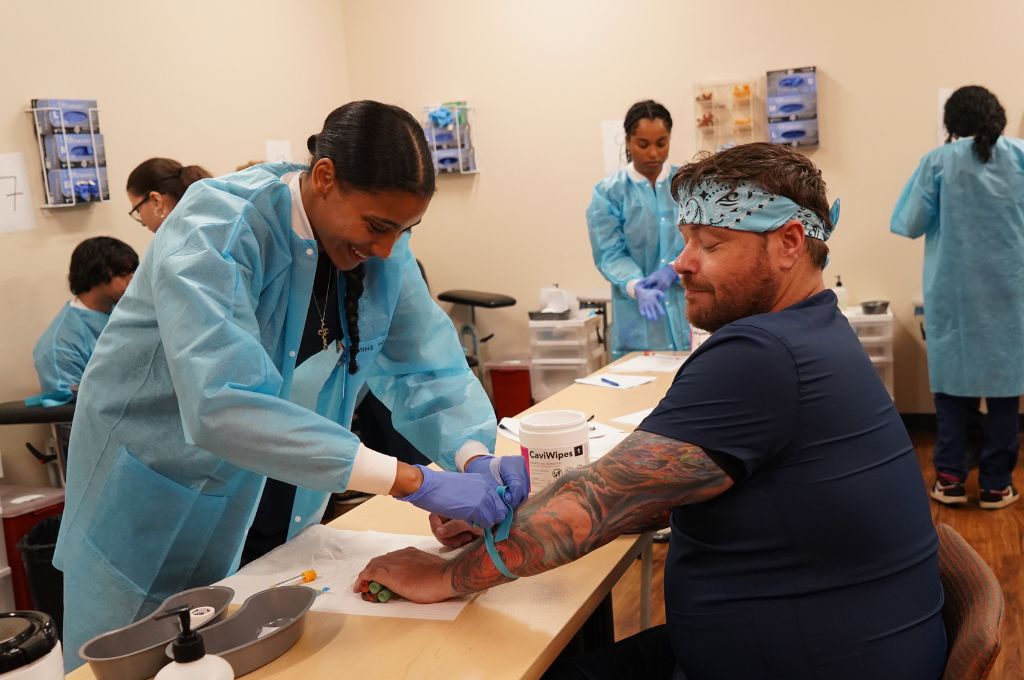 An adult healthcare student receiving hands-on clinical instruction